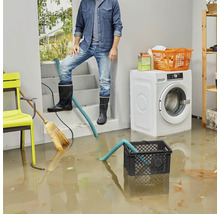 Zaplavený sklep s mužem v gumových botách, pumpou a pračkou