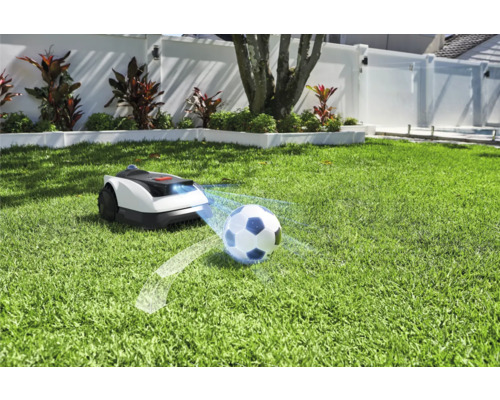 Robotická sekačka na trávníku s fotbalovým míčem