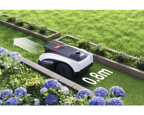 Robotická sekačka na zahradě mezi záhony a trávníky