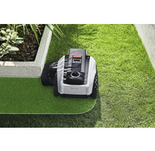 Robotická sekačka na trávu při péči o trávník v zahradě.