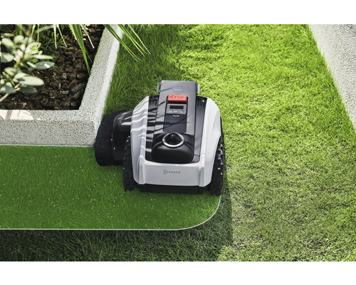 Robotická sekačka na trávu při péči o trávník v zahradě.