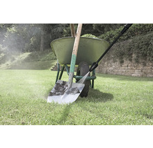 Čištění rýče vysokotlakým čističem vedle kolečka na zahradě