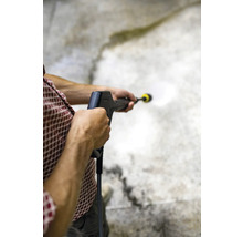 Osoba používá vysokotlaký čistič k čištění povrchu.