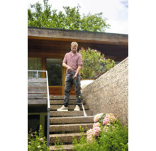 Muž čistí venkovní schodiště vysokotlakým čističem.