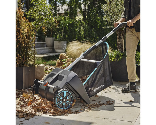 Zahradní scéna se sběračem listí v provozu, který sbírá listí.