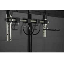 Nástěnný upevňovací systém s různými háky pro ukládání předmětů