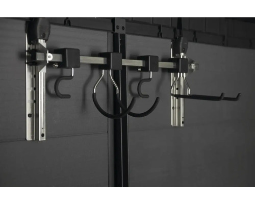 Nástěnný upevňovací systém s různými háky pro ukládání předmětů