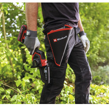 Osoba s akumulátorovou prořezávací pilou Einhell a pouzdrem s logem Einhell