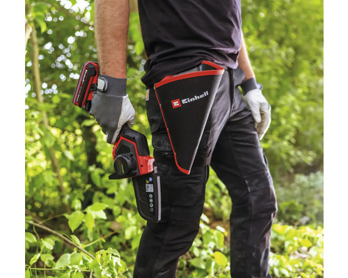 Osoba s akumulátorovou prořezávací pilou Einhell a pouzdrem s logem Einhell