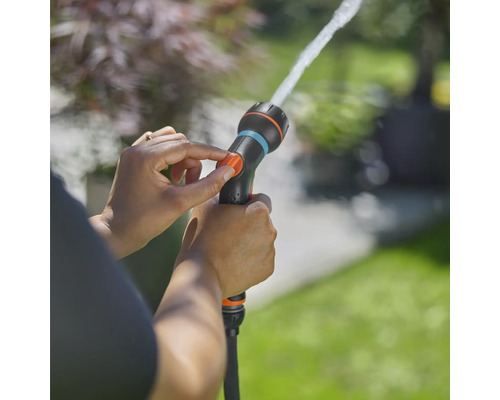 Zahradní hadicová tryska v provozu s nastavitelným proudem vody