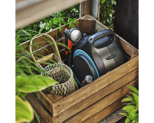 Box na zahradní hadici s rozstřikovací pistolí v dřevěné bedně