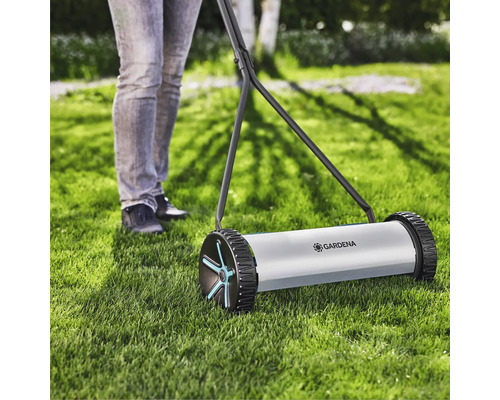 Ruční sekačka na trávu Gardena v provozu na trávníku