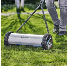 Ruční sekačka na trávu při práci na trávníku s logem Gardena