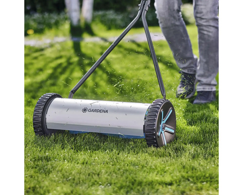 Ruční sekačka na trávu při práci na trávníku s logem Gardena