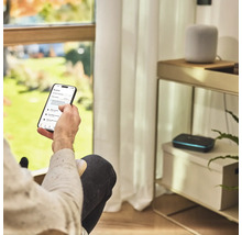 Osoba ovládá aplikaci pro zavlažování zahrady na smartphonu