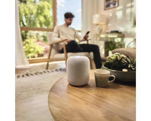 Zařízení obývacího pokoje s chytrým reproduktorem na stole.