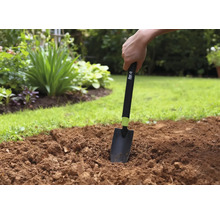 Práce na zahradě s ruční lopatkou na záhonu