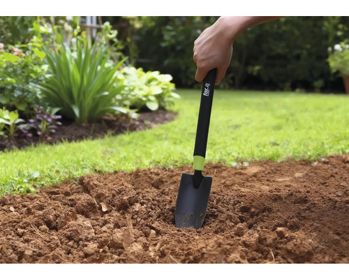 Práce na zahradě s ruční lopatkou na záhonu