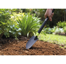 Osoba používá zahradní lopatku na záhoně.