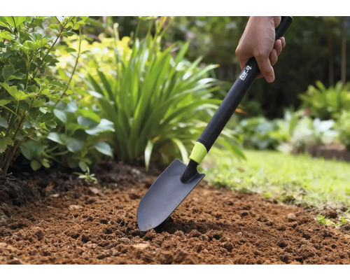 Osoba používá zahradní lopatku na záhoně.