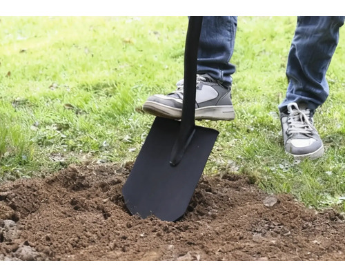 Osoba bodá rýčem do země.