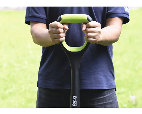 Osoba drží rýč s rukojetí ve tvaru písmene D.