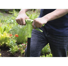 Osoba používá v zahradě plečku.