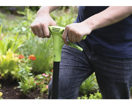 Osoba používá v zahradě plečku.