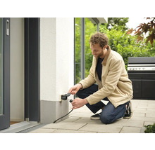 Muž připojuje zástrčku do venkovní zásuvky