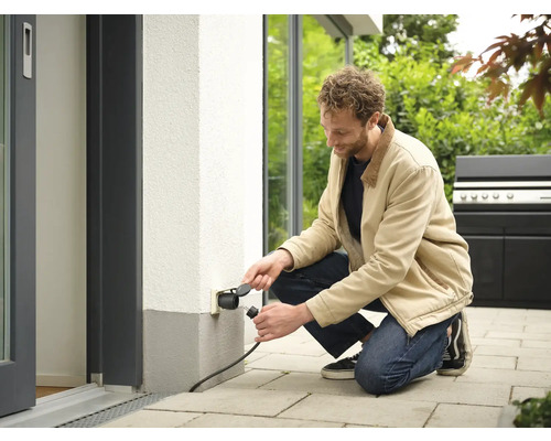 Muž připojuje zástrčku do venkovní zásuvky