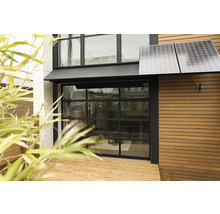 Vnější pohled na dům se solárními panely a skleněnými garážovými vraty