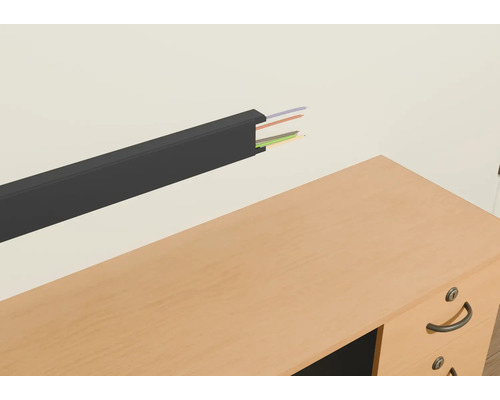 Plastový kabelový kanál s kabely na zdi nad stolem