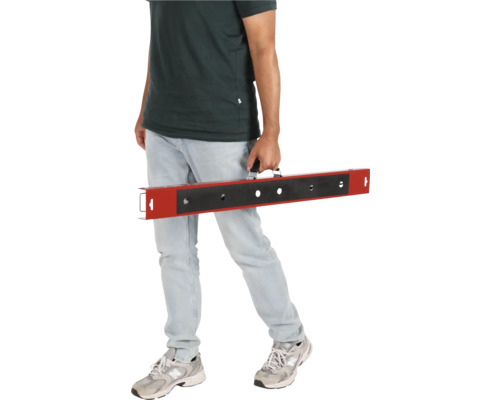 Muž nese nivelační tyč