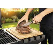 Příprava masa na grilu s prkénkem a nožem.