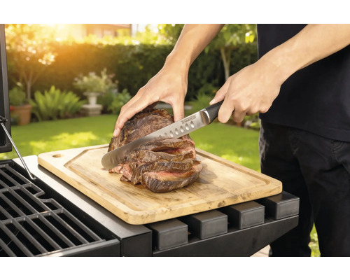 Příprava masa na grilu s prkénkem a nožem.