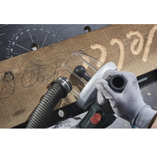 Obrábění dřeva pomocí frézovacího nástroje k vytvoření písma do dřevěné desky