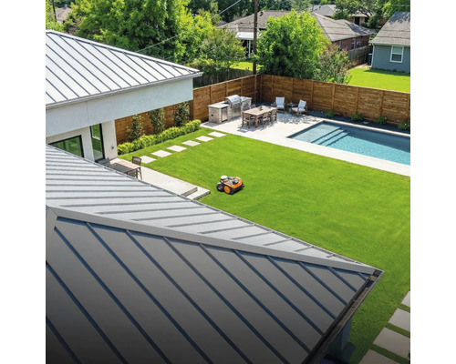 Pohled na dům s trávníkem, bazénem a robotickou sekačkou