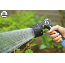 Ruka drží zahradní postřikovač při zavlažování