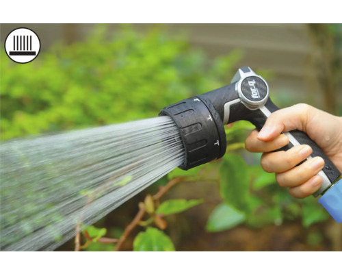 Ruka drží zahradní postřikovač při zavlažování