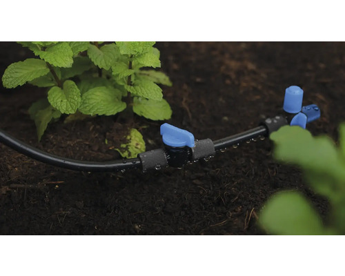 Zavlažovací systém s kapací hadicí a uzavíracím ventilem v zahradním záhonu