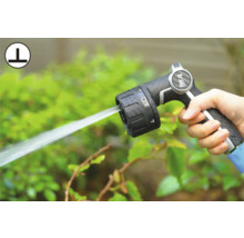 Ruka drží zahradní hadicovou pistoli s nastavitelnými režimy stříkání.