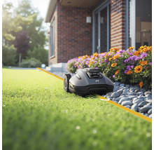 Robotická sekačka na trávníku před domem