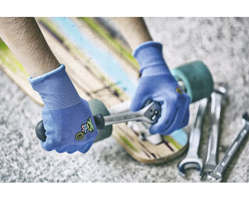 Osoba opravuje skateboard pomocí klíče a rukavic