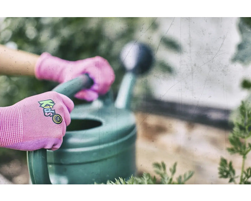 Ruce v dětských rukavicích drží konev