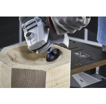 Obrábění dřeva úhlovou bruskou tvaruje mísu v dřevěném bloku.