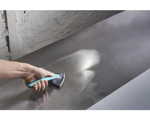 Ruka používá brusný blok k vyhlazení kovového povrchu.