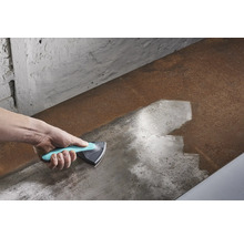 Ruka s trojúhelníkovou škrabkou čistící kovový povrch