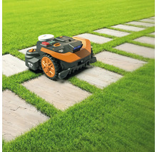 Robotická sekačka na trávníku s cestou z kamenných desek