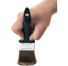 Ruka drží plochý štětec o šířce 50 milimetrů