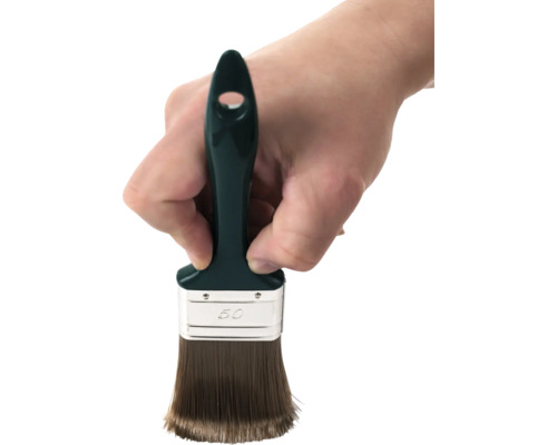 Ruka drží plochý štětec o šířce 50 milimetrů